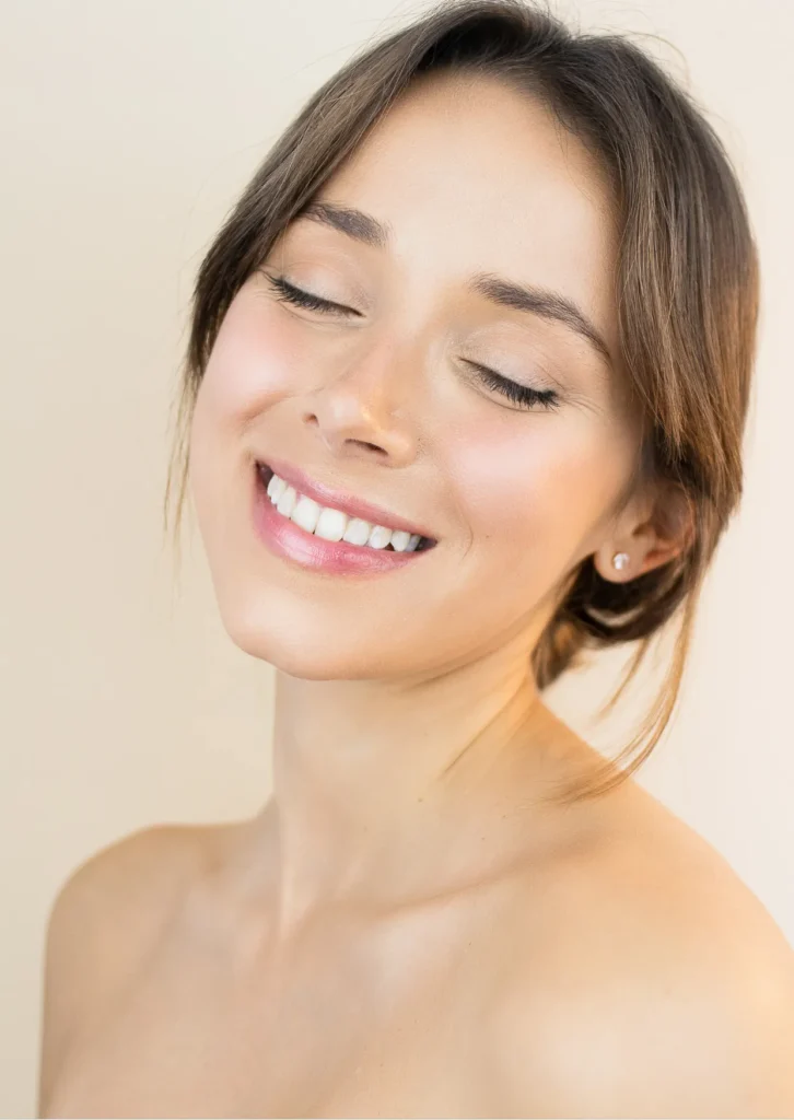 Woman with naturally balanced facial features, smooth skin, soft smile, and harmonious proportions, representing facial balancing aesthetic treatments.